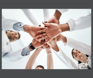 doctors joining hands as part of team gesture