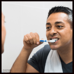 a man brushing his teeth in front of a mirror
